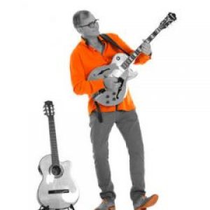 nic orange skjorte spiller el gitar med klasssisk i stativ4343-0018n-r